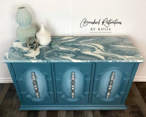 A blue cabinet with a marble top and white accents.