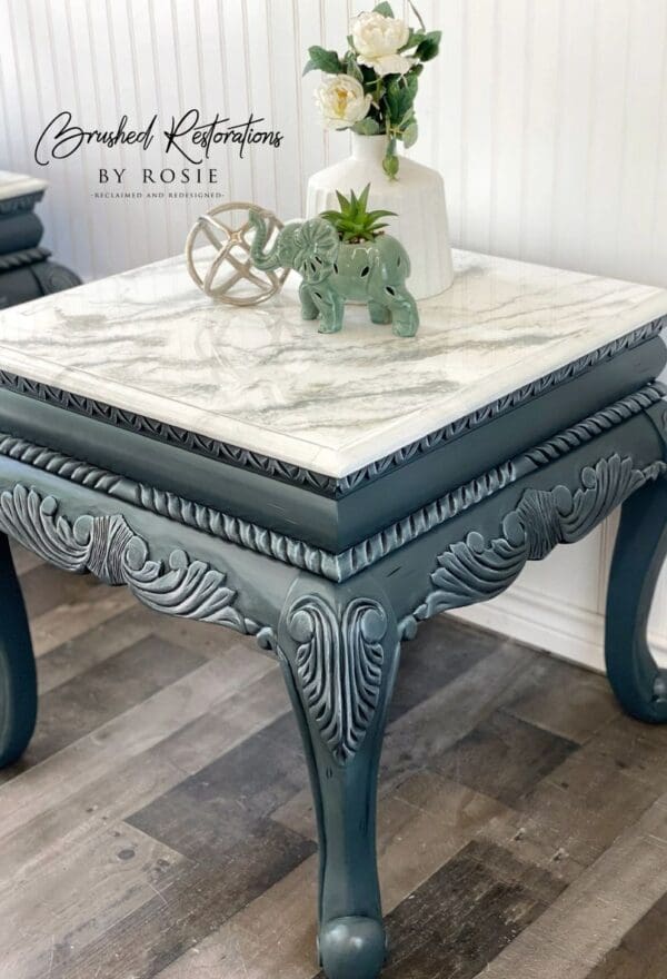 A table with white marble top and blue painted legs.