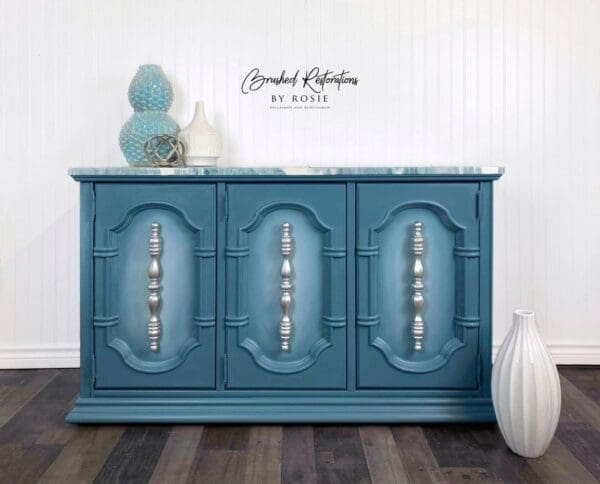 A blue cabinet with three drawers and two doors.