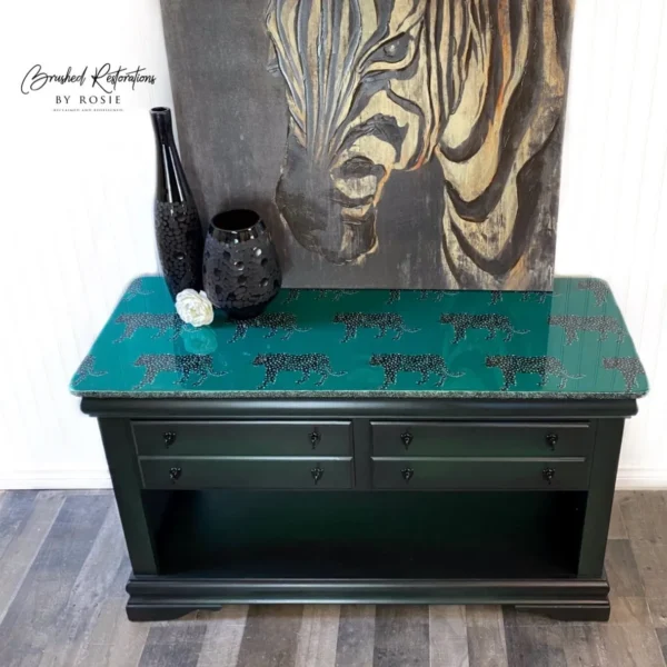 A black table with green top and tiger print on it.