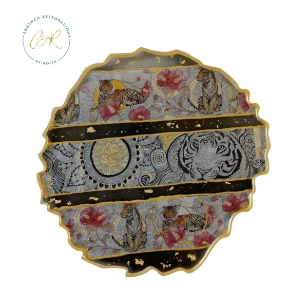 A round shaped plate with gold trim and floral design.