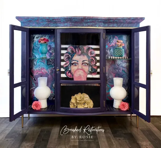 A display cabinet with a paint pour on side panels and a bright image of a lady with bubble gum coming from mouth.