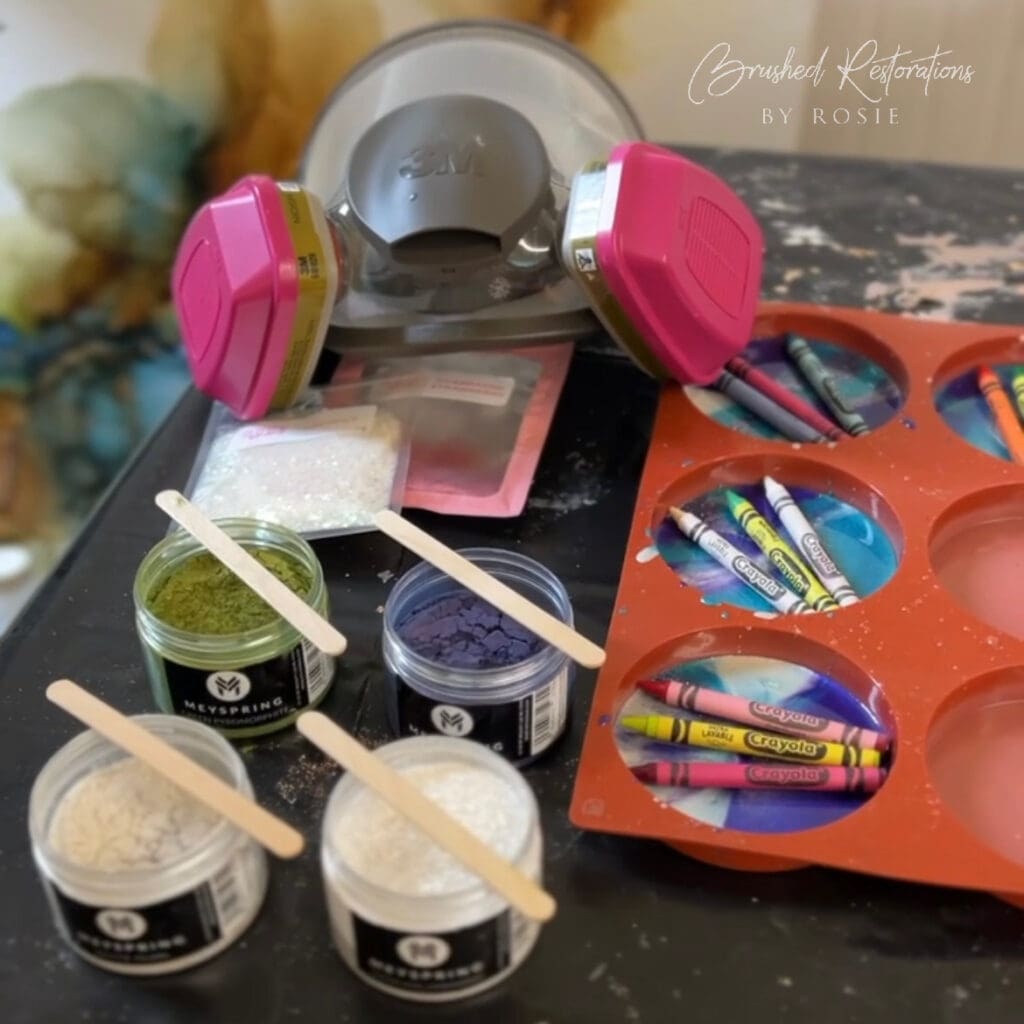 Final touches being applied to resin DIY crayon coasters, featuring a mask and colored mica powders on a craft table. Showcases the detailed and colorful finishing steps in creating resin crafts.

