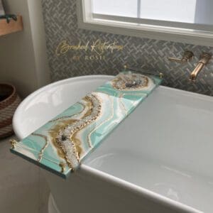 Beautiful teal resin board laying over a bathtub. Has sea of crystals and acrylic pulls