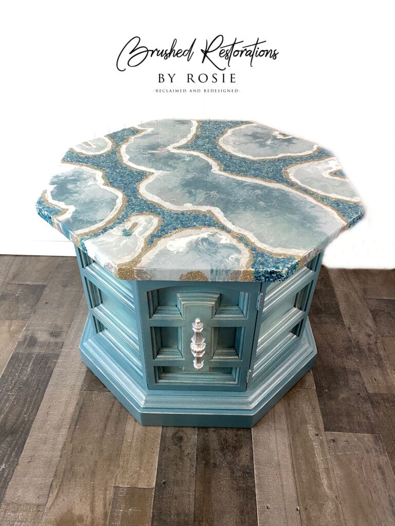 Artistic resin tabletop on a refurbished vintage corner table in teal, adorned with intricate geode designs by Rosie from Brushed Restorations.